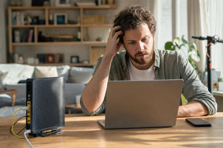 Homme frustré devant ordinateur portable